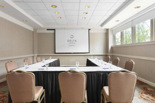 a conference room with a table and chairs and a screen at Delta Hotels by Marriott Baltimore North in Baltimore