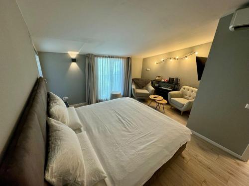 a bedroom with a white bed and a living room at Villa Jasmine in Bolzano