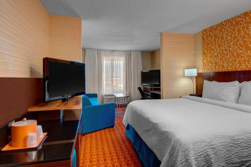 a hotel room with a bed and a flat screen tv at Fairfield Inn & Suites by Marriott Fort Worth I-30 West Near NAS JRB in Fort Worth
