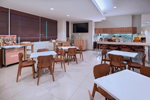 un restaurant avec des tables et des chaises et une cuisine dans l'établissement Element Houston Vintage Park, à Houston