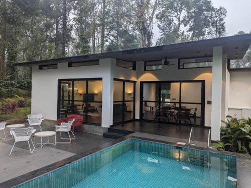 a house with a swimming pool in front of it at Birdsong Luxury Pool Villa by Luxunlock Private Villas in Suntikoppa