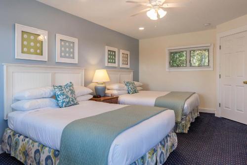 A bed or beds in a room at Glen Cove Inn & Suites Rockport