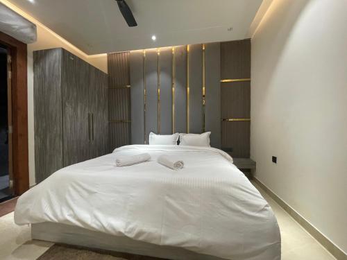 a bedroom with a large white bed with white sheets at Marine Ganga Stays in Rishīkesh
