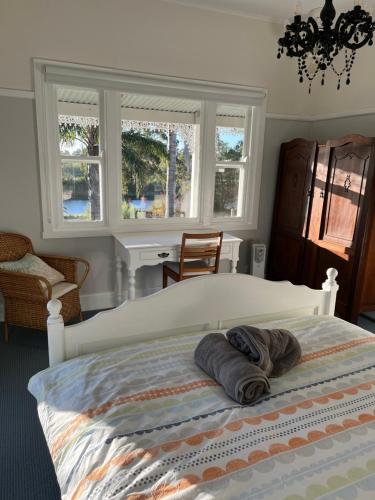 a bedroom with a bed with two towels on it at Bylands Cottage Historic Home - Tambo river views and pet friendly in Swan Reach