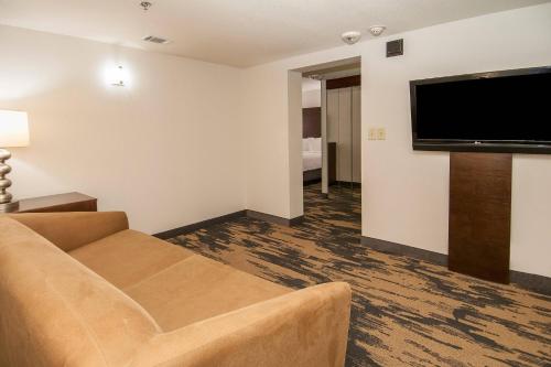 a living room with a couch and a flat screen tv at Fairfield Inn & Suites by Marriott Dallas DFW Airport South/Irving in Irving