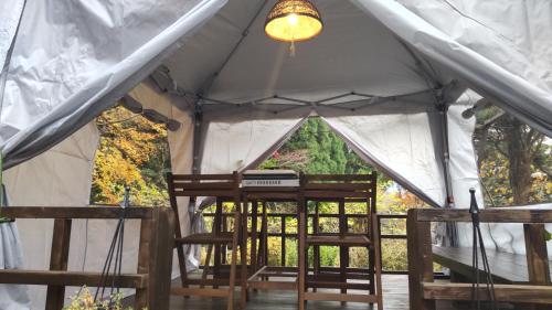 a tent with two chairs and a light at 民泊haruna in Yufuin
