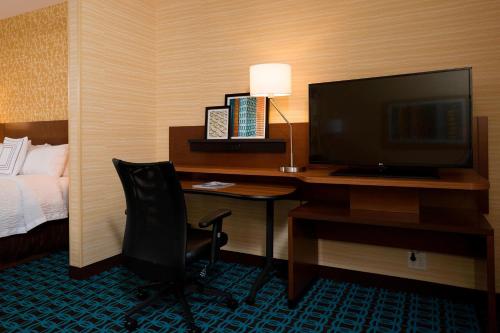a hotel room with a desk with a television and a bed at Fairfield Inn & Suites by Marriott Durango in Durango