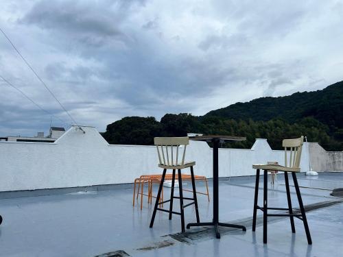 two chairs and a table on top of a roof at Hotel Bali Moon in Toi