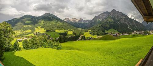 a view of a green field with mountains in the background at Haus Garni Luggi Leitner in Mittelberg