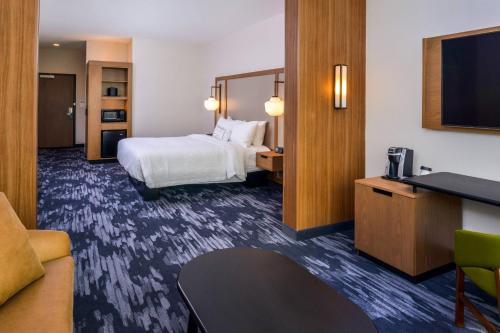 a hotel room with a bed and a flat screen tv at Fairfield Inn & Suites by Marriott Fort Worth Southwest at Cityview in Fort Worth