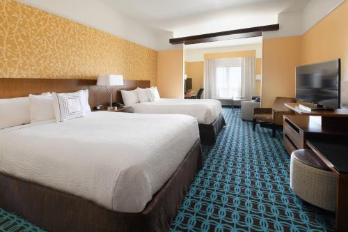 a hotel room with two beds and a flat screen tv at Fairfield Inn & Suites by Marriott Fort Worth South/Burleson in Burleson