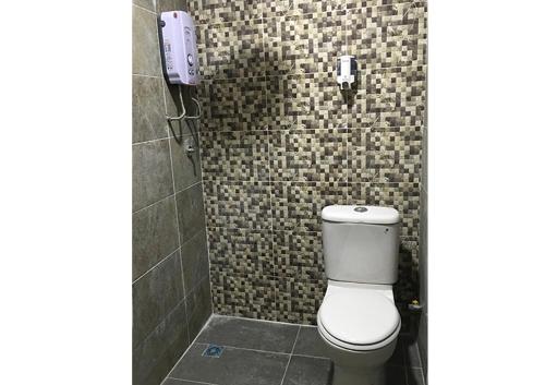 a bathroom with a toilet and a phone on the wall at Sri Kilim Resthouse and Homestay Langkawi in Kilim