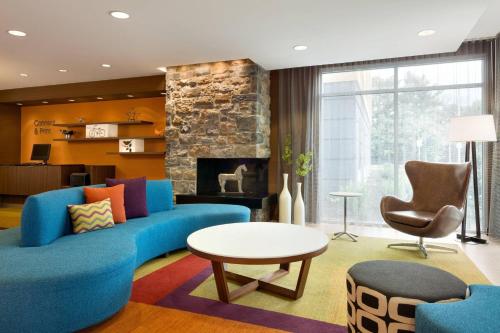 a living room with a blue couch and a fireplace at Fairfield Inn & Suites by Marriott Lancaster East at The Outlets in Lancaster