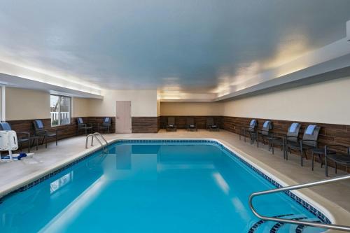a pool in a hotel room with chairs at Fairfield Inn & Suites Kansas City Airport in Kansas City