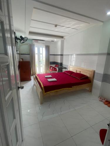 Khách Sạn Kim Thanh في مدينة هوشي منه: غرفة نوم بها سرير وبطانية حمراء