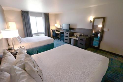 a hotel room with two beds and a desk at Fairfield Inn & Suites Des Moines Airport in Des Moines