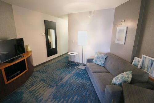 a living room with a couch and a flat screen tv at Fairfield Inn & Suites Des Moines Airport in Des Moines