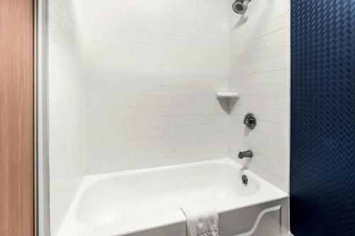 a white bath tub in a white tile bathroom at Fairfield Inn & Suites by Marriott San Antonio Downtown/Market Square in San Antonio