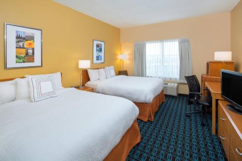 a hotel room with two beds and a flat screen tv at Fairfield Inn & Suites by Marriott San Antonio Airport/North Star Mall in San Antonio
