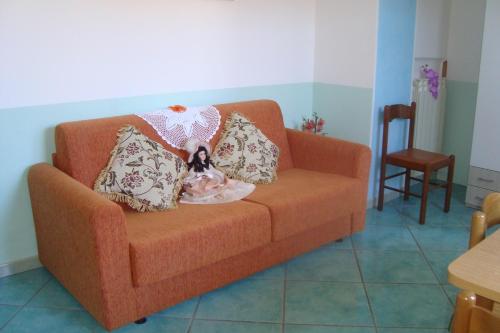 a dog sitting on a couch with pillows at B&B Oliva in Scala