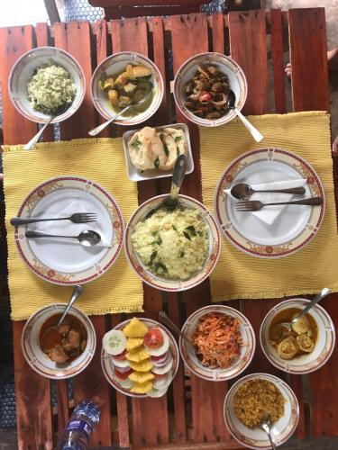 a table with many plates of food on it at Ruki's Homestay in Hatton