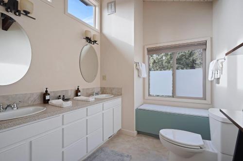 a bathroom with a sink and a toilet and a window at Pine Knoll in Bend
