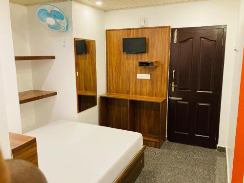 a small room with a bed and a door at CARMEL HOME STAY in Munnar