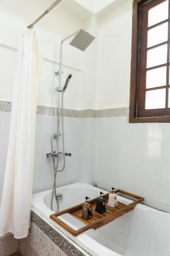 a bathroom with a bath tub with a shower at Hanuman Boutique Stay &Eatery in Hat Yai
