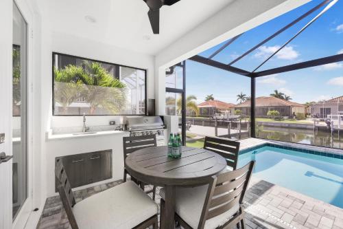 a kitchen and dining room with a table and a swimming pool at 2024 Monsterrat model waterfront home with lap pool in Marco Island