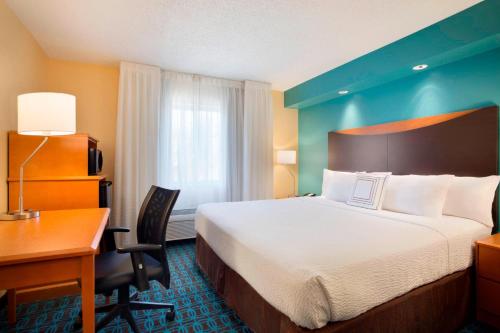 a hotel room with a bed and a desk and a computer at Fairfield Inn & Suites Fort Worth University Drive in Fort Worth
