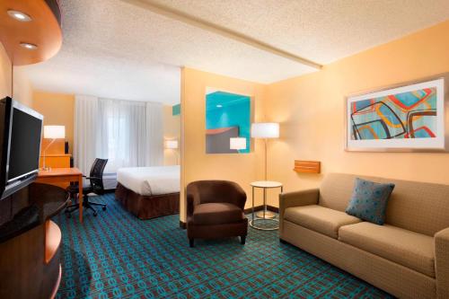a hotel room with a couch and a bed at Fairfield Inn & Suites Fort Worth University Drive in Fort Worth