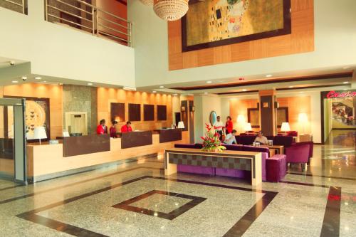 a lobby of a hotel with people sitting in the lobby at Ramada by Wyndham Princess Georgetown in Georgetown