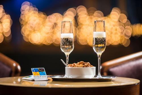 two champagne glasses and a bowl of food on a table at Bo33 Hotel Family & Suites in Budapest