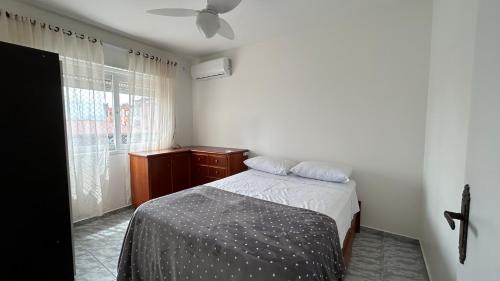 En eller flere senge i et værelse på Aconchegante apartamento 2 dormitórios no centro com vaga