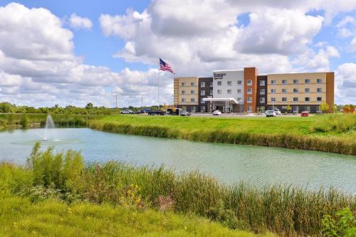 a river in front of a building with an american flag at Fairfield Inn & Suites by Marriott Warrensburg in Warrensburg