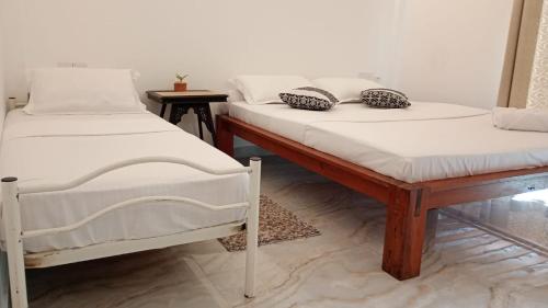 two beds sitting next to each other in a room at Valentine's Lodge in Ampitiya