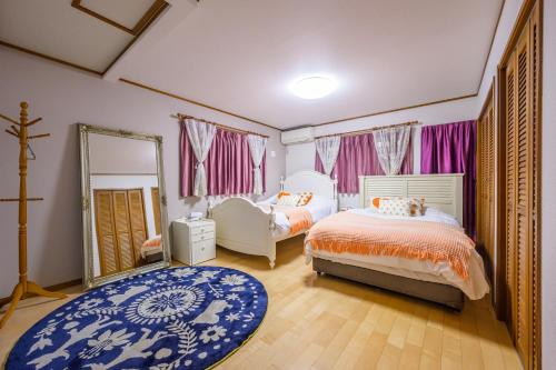 a bedroom with two beds and a mirror at Nakano Shinjuku Sapphire Single-family House in Tokyo