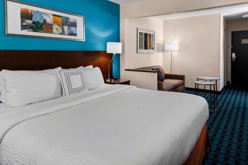 Una habitación de hotel con una cama grande y una silla. en Fairfield Inn by Marriott Dothan, en Dothan
