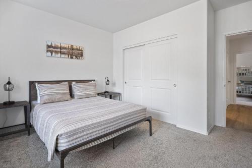 a white bedroom with a bed with white walls at Four Seasons Retreat in Sunriver