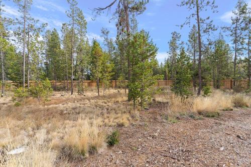 a field with trees and a fence in the background at Four Seasons Retreat in Sunriver