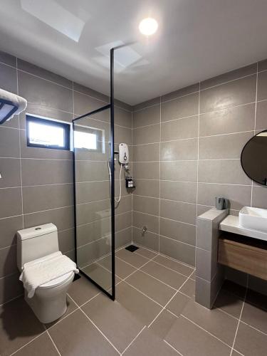 a bathroom with a shower and a toilet and a sink at Hotel Ivory Papar in Papar