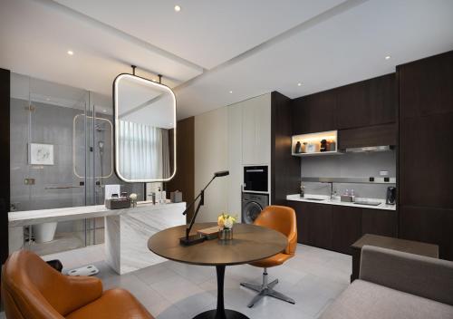 uma sala de estar com mesa e cadeiras em Wanda Yi Hotel Chengdu em Chengdu