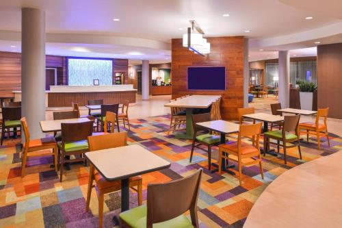 a restaurant with tables and chairs and a bar at Fairfield Inn & Suites Orlando Ocoee in Orlando