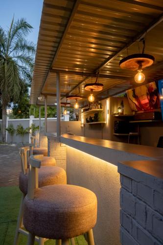 a bar with a row of stools in front of it at The L Boutique Tz in Dar es Salaam