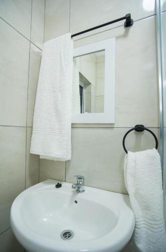 a bathroom with a white sink and a mirror at Cape Dreamland in Cape Town
