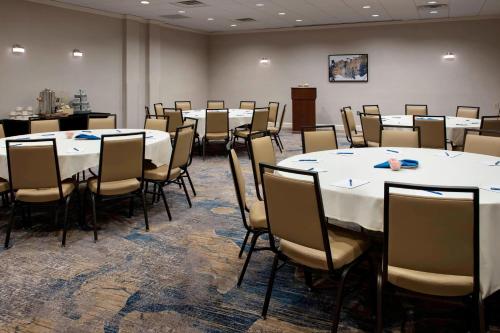 a conference room with white tables and chairs at Delta Hotels by Marriott Utica in Utica