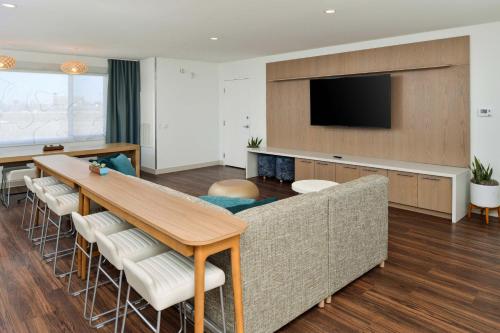 a living room with a couch and a table and a television at Element North Kansas City in Kansas City