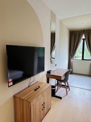 a living room with a flat screen tv on the wall at Hotel Ivory Papar in Papar