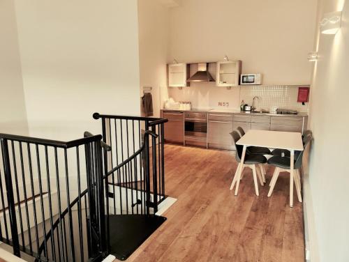 a kitchen with a table and a dining room at PENTHOUSE APARTMENT - FREE GARAGED Parking - BALCONY - GYM in Dewsbury