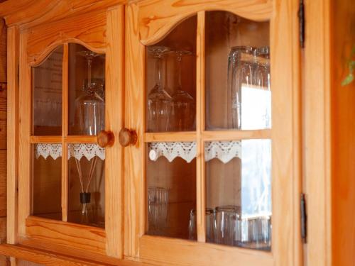 a wooden cabinet with glass doors filled with glasses at Chalet Nase at 1700m in the Zillertal in Grün